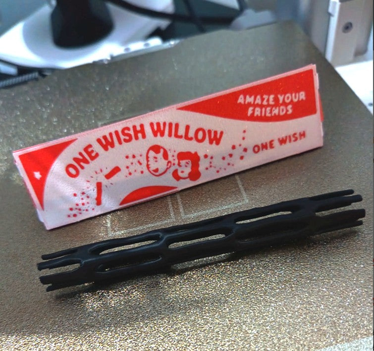 One Wish Willow, black 3D printed charm with its red and white printed sleeve